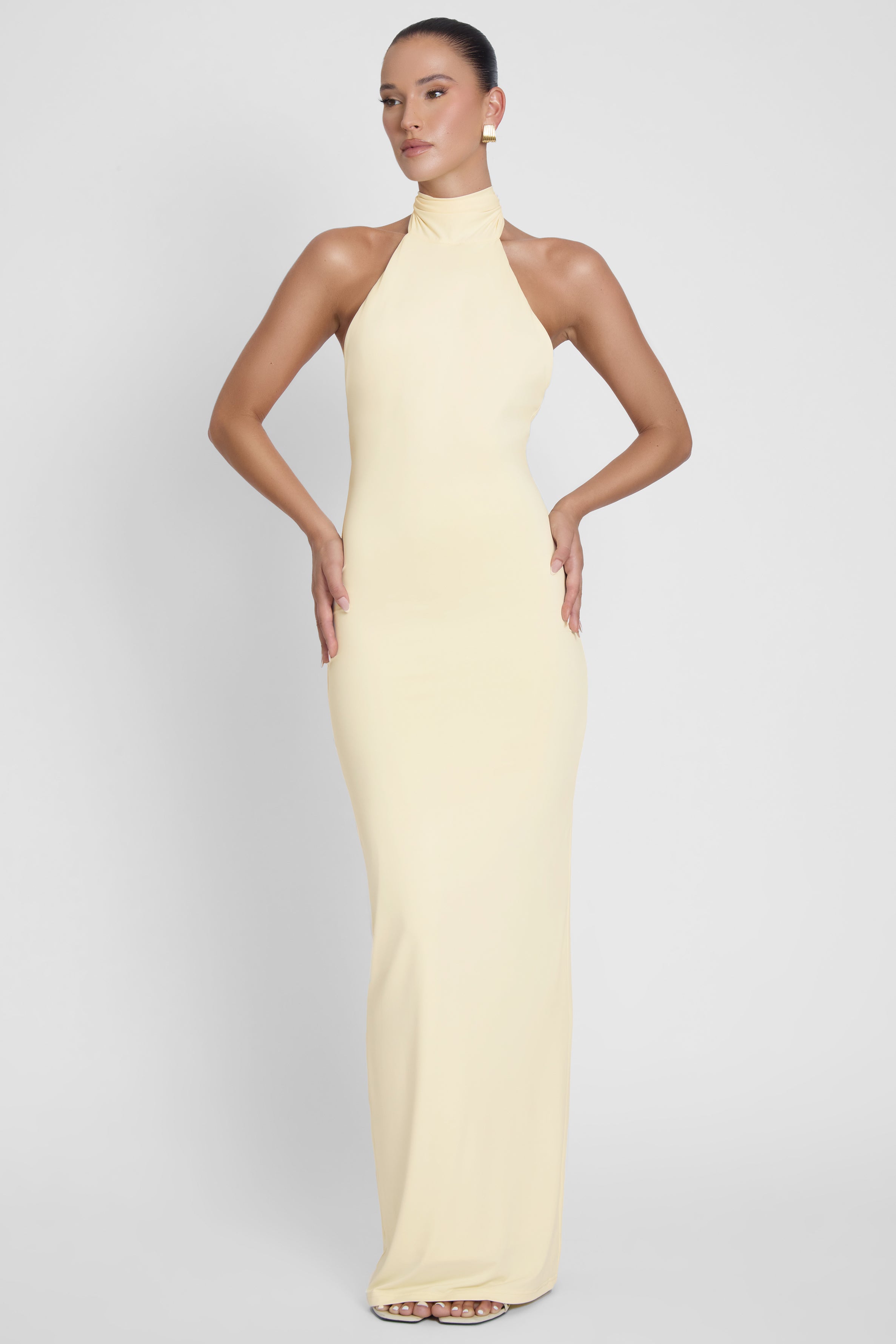 Model is wearing Alaia Drape Maxi Dress Yellow, front view.