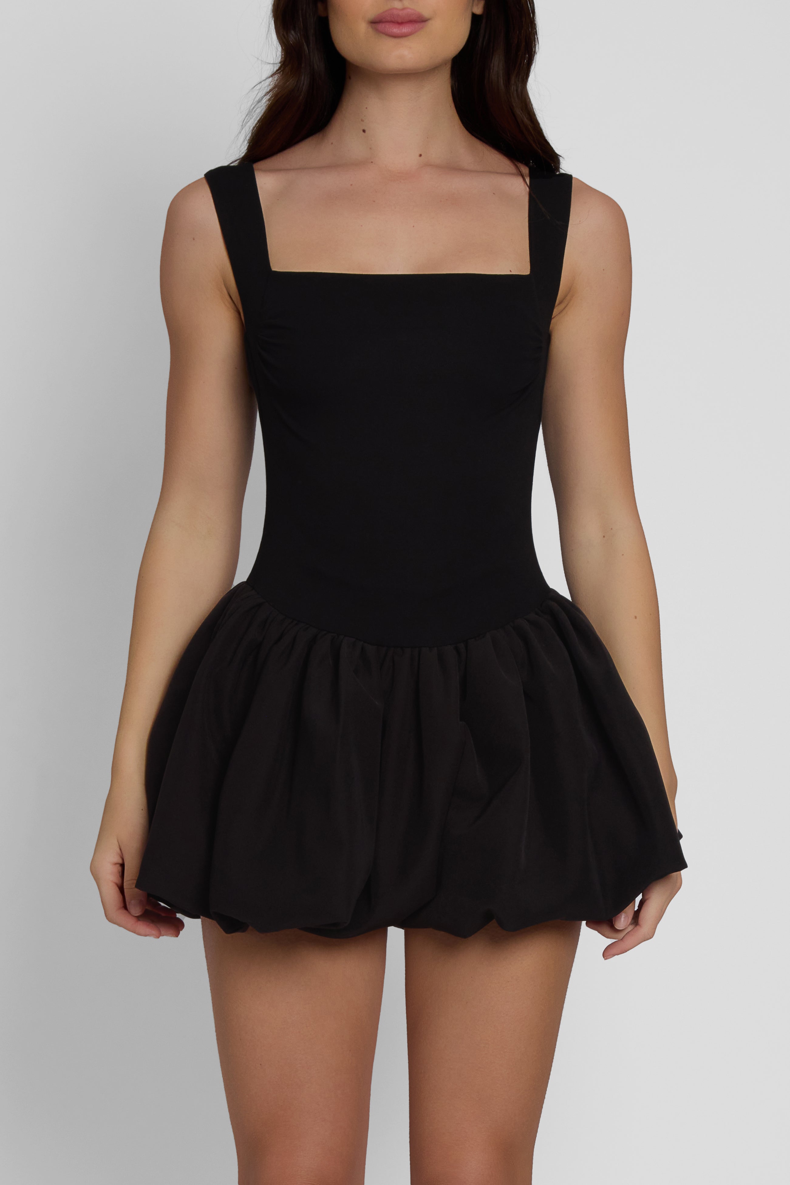 Model wearing Bisou Bubble Knit Mini Dress in Black, front view.