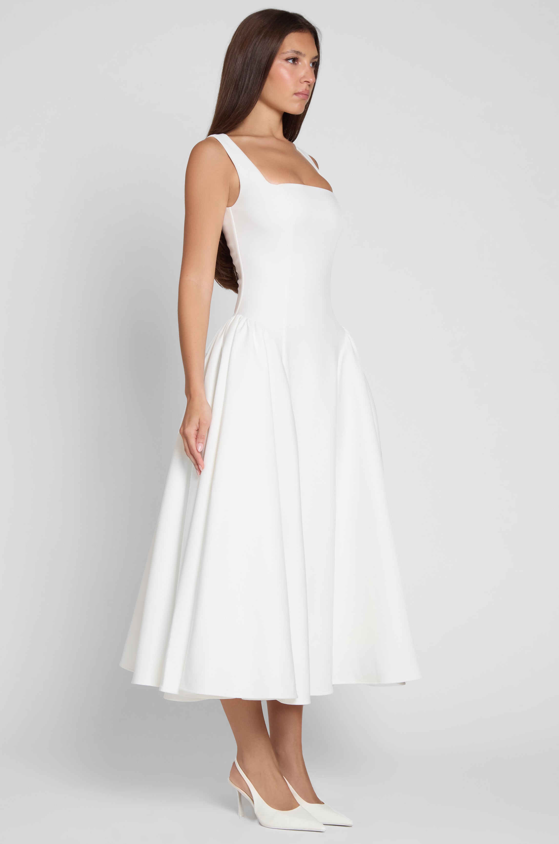 Model is wearing Chloe Corset Midi Dress White, side view.