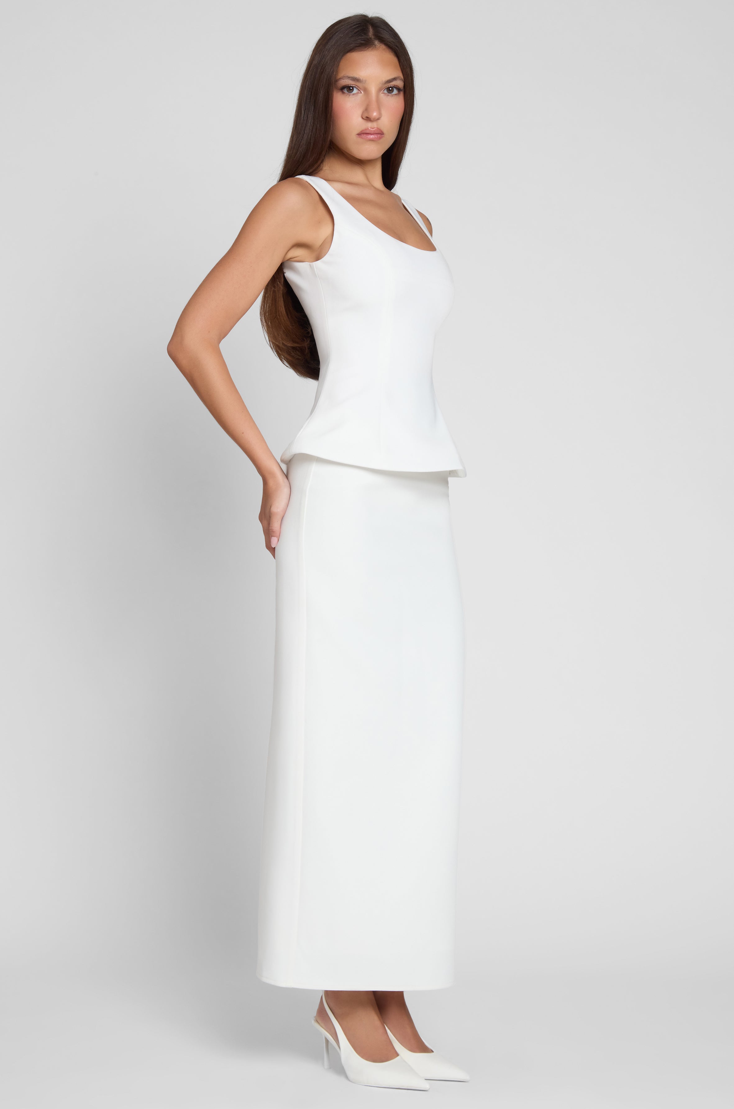 Model is wearing Classic Column Maxi Skirt in White, side view.