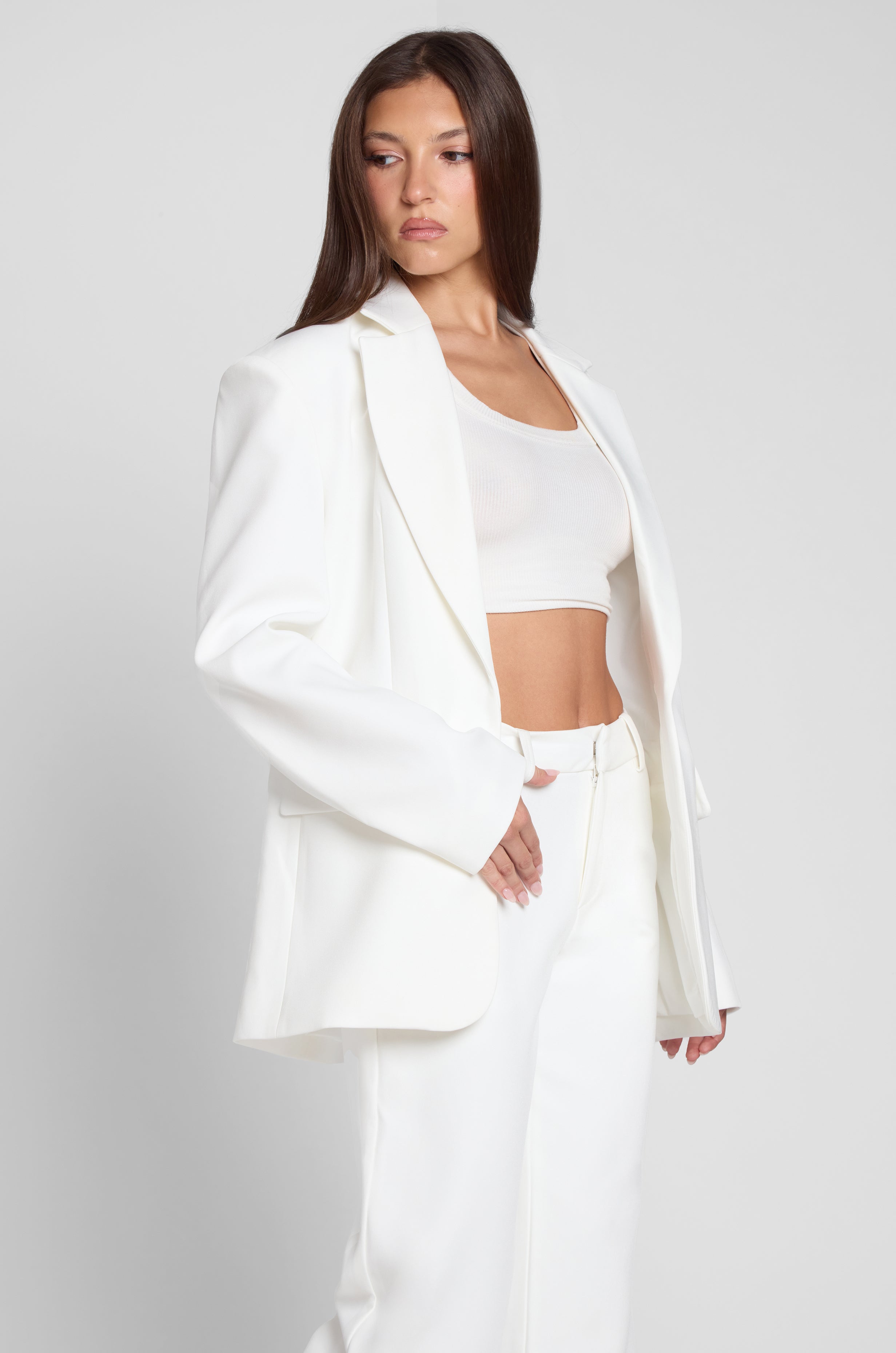 Model is wearing Classic Column Oversized Blazer in White, side view.