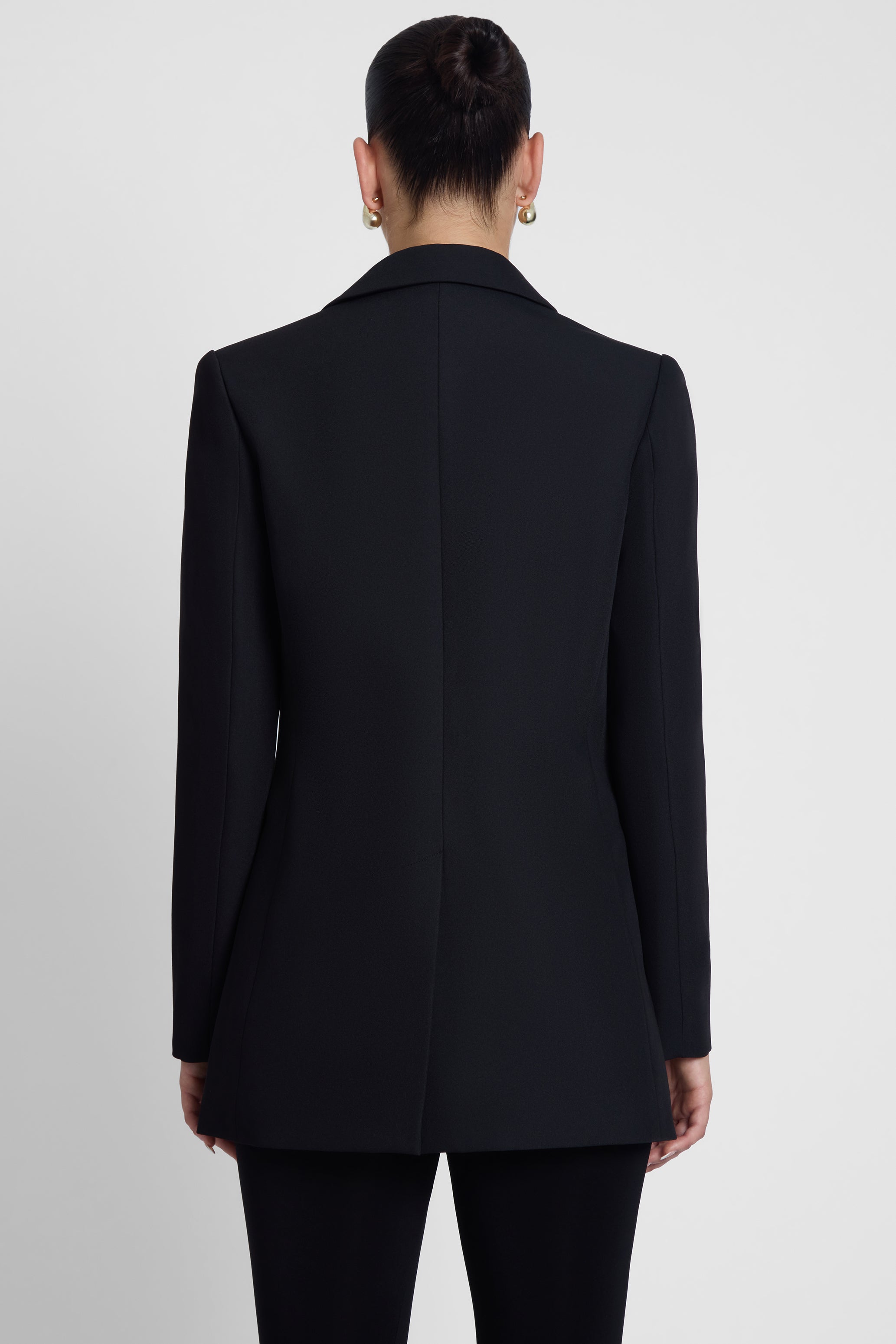 Model is wearing Classic Column Tailored Belted Blazer Black, back view.