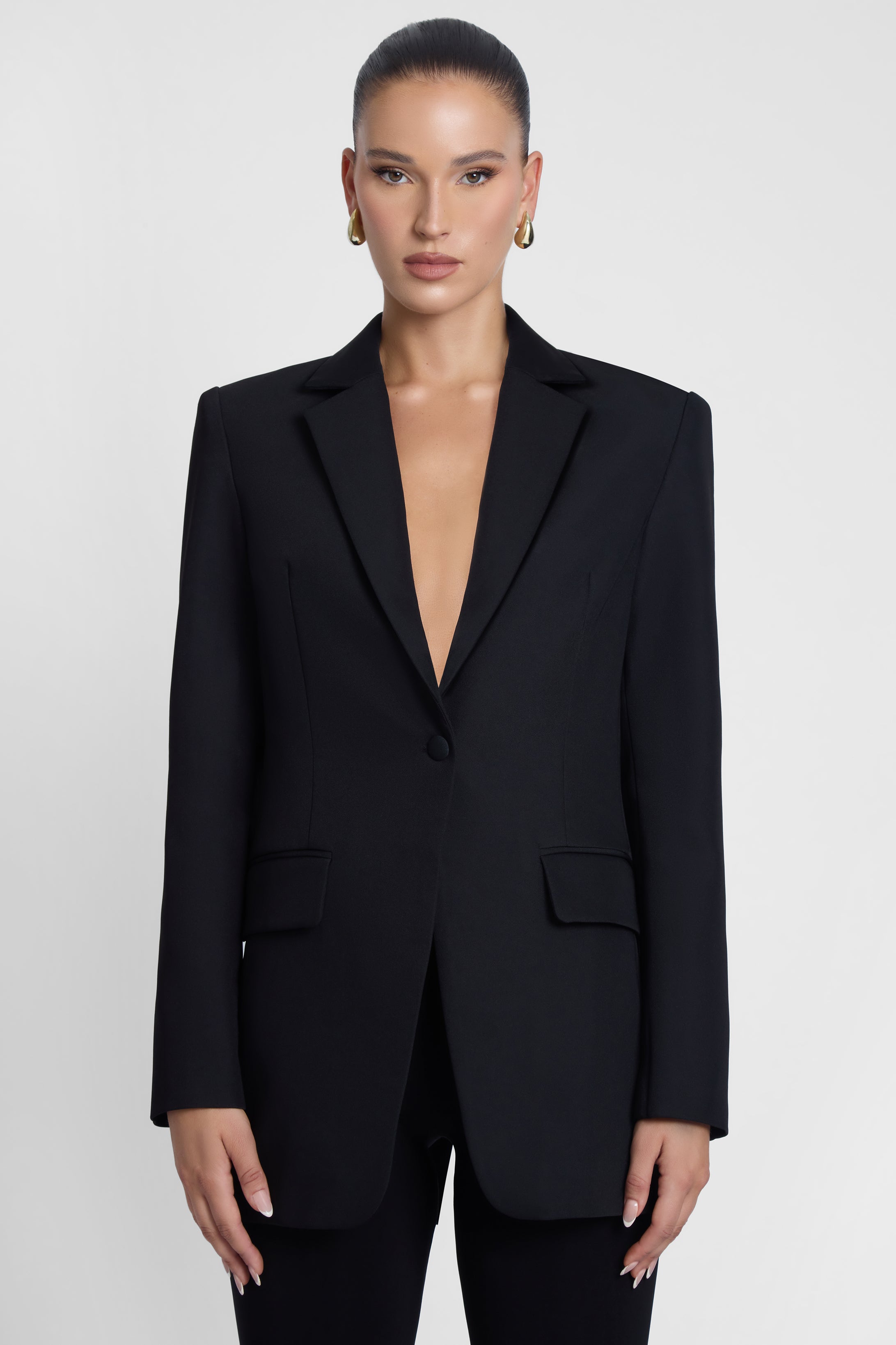 Model is wearing Classic Column Tailored Belted Blazer Black, front view.