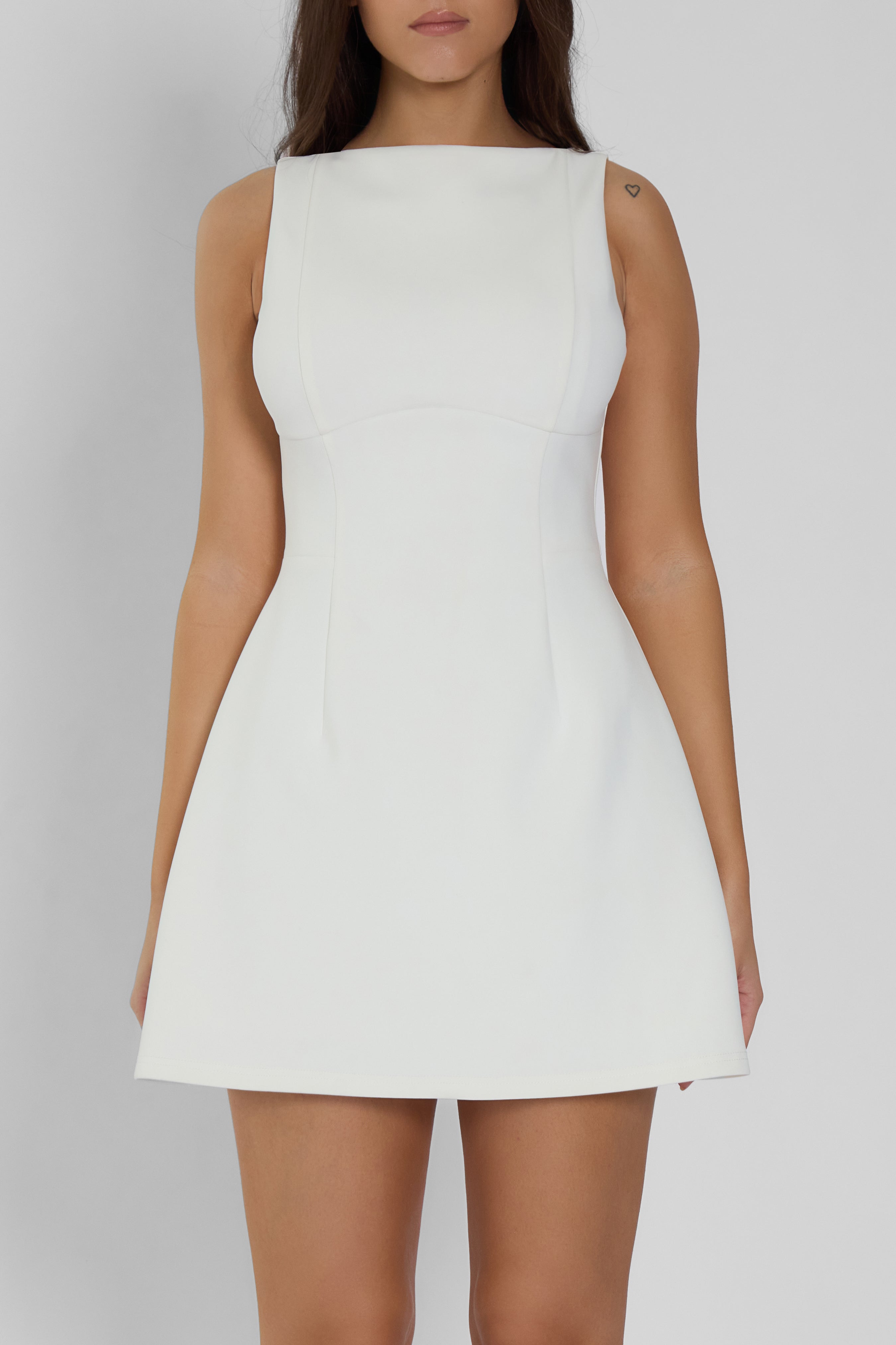 Model wearing Estelle Sleeveless Bustier Mini Dress in White, front view.