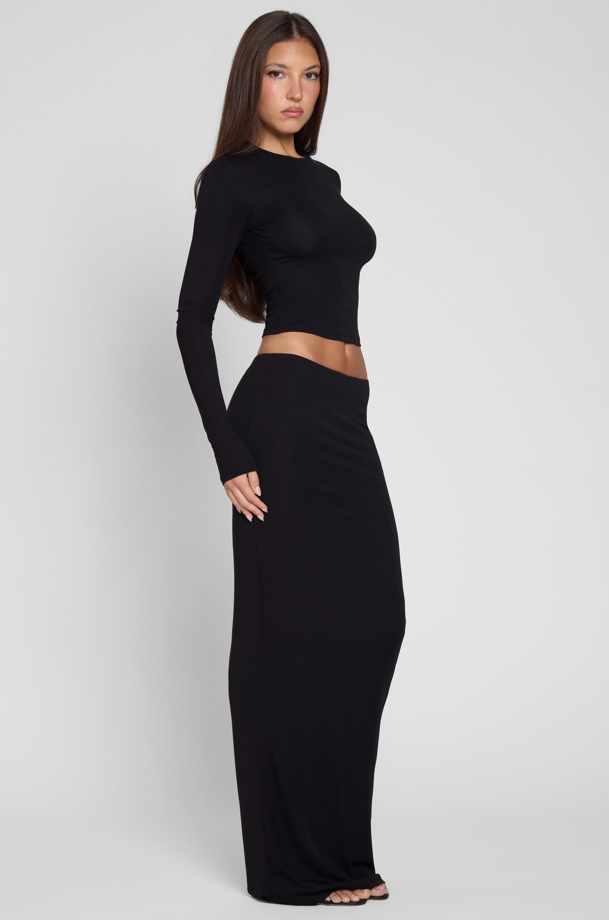 Model is wearing Everyday Jersey Maxi Skirt in Black, side view.