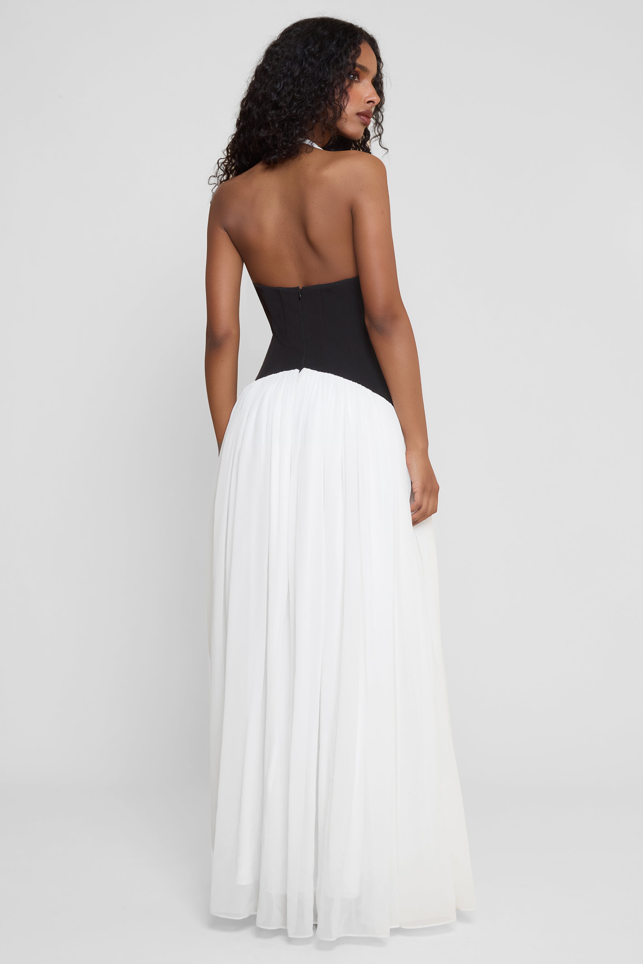 Model wearing Harlowe Contrast Corset Maxi Dress in White, back view.