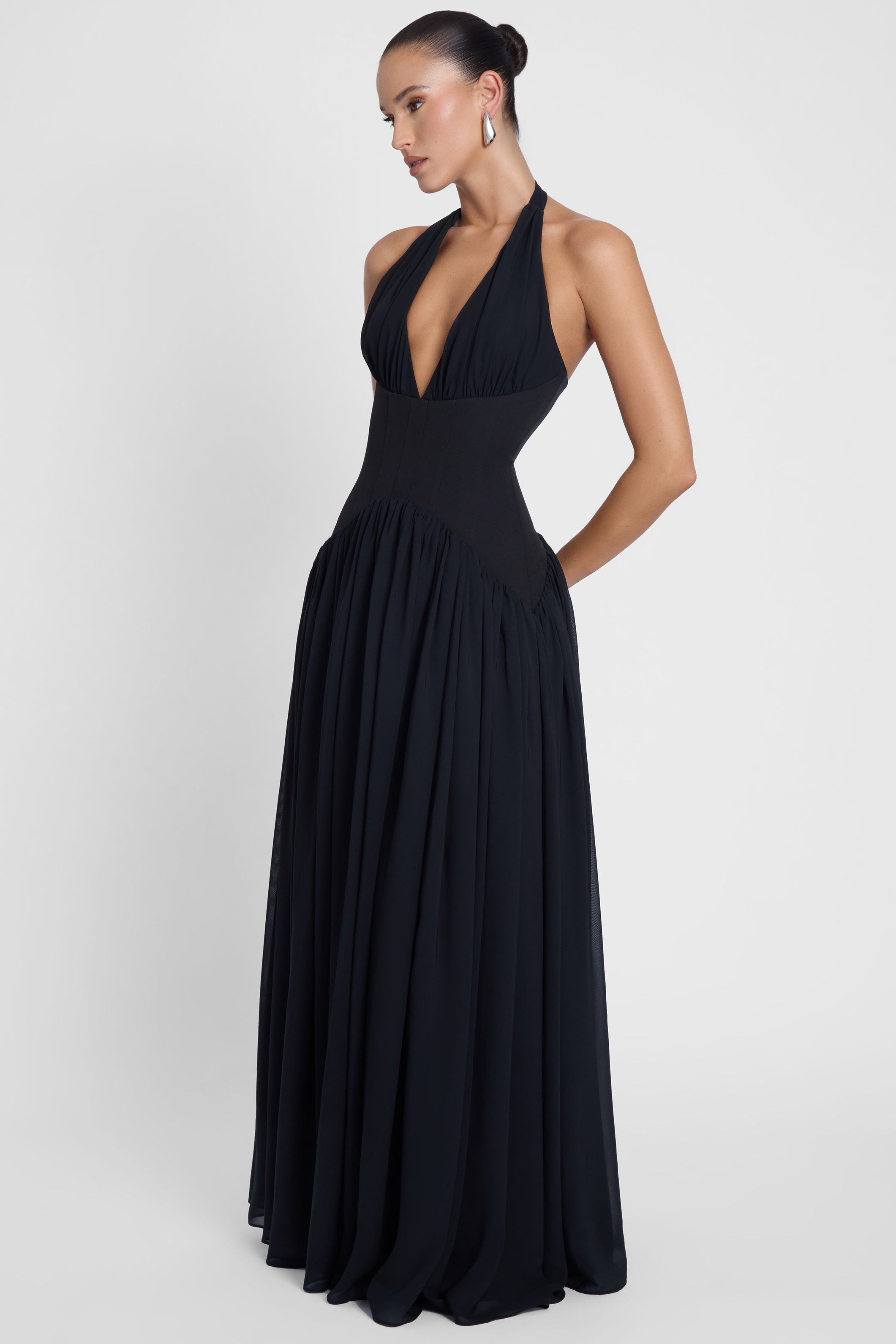 Model is wearing Harlowe Corset Maxi Dress Black, front view.