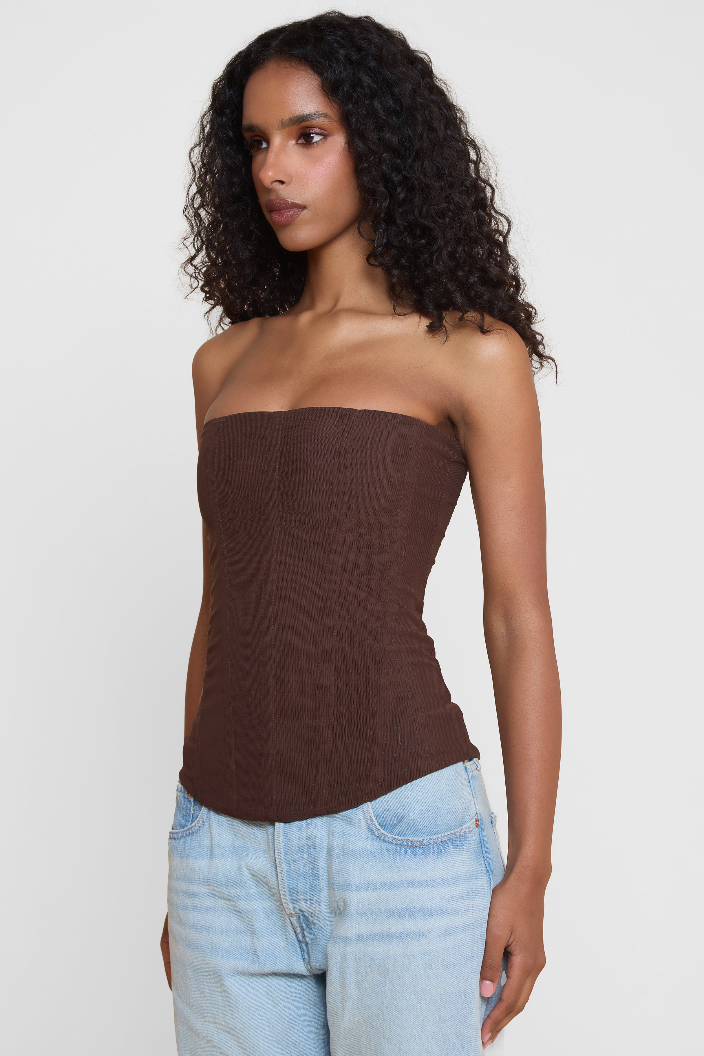Model wearing Muse Mesh Corset Top in Chocolate Brown, side view.