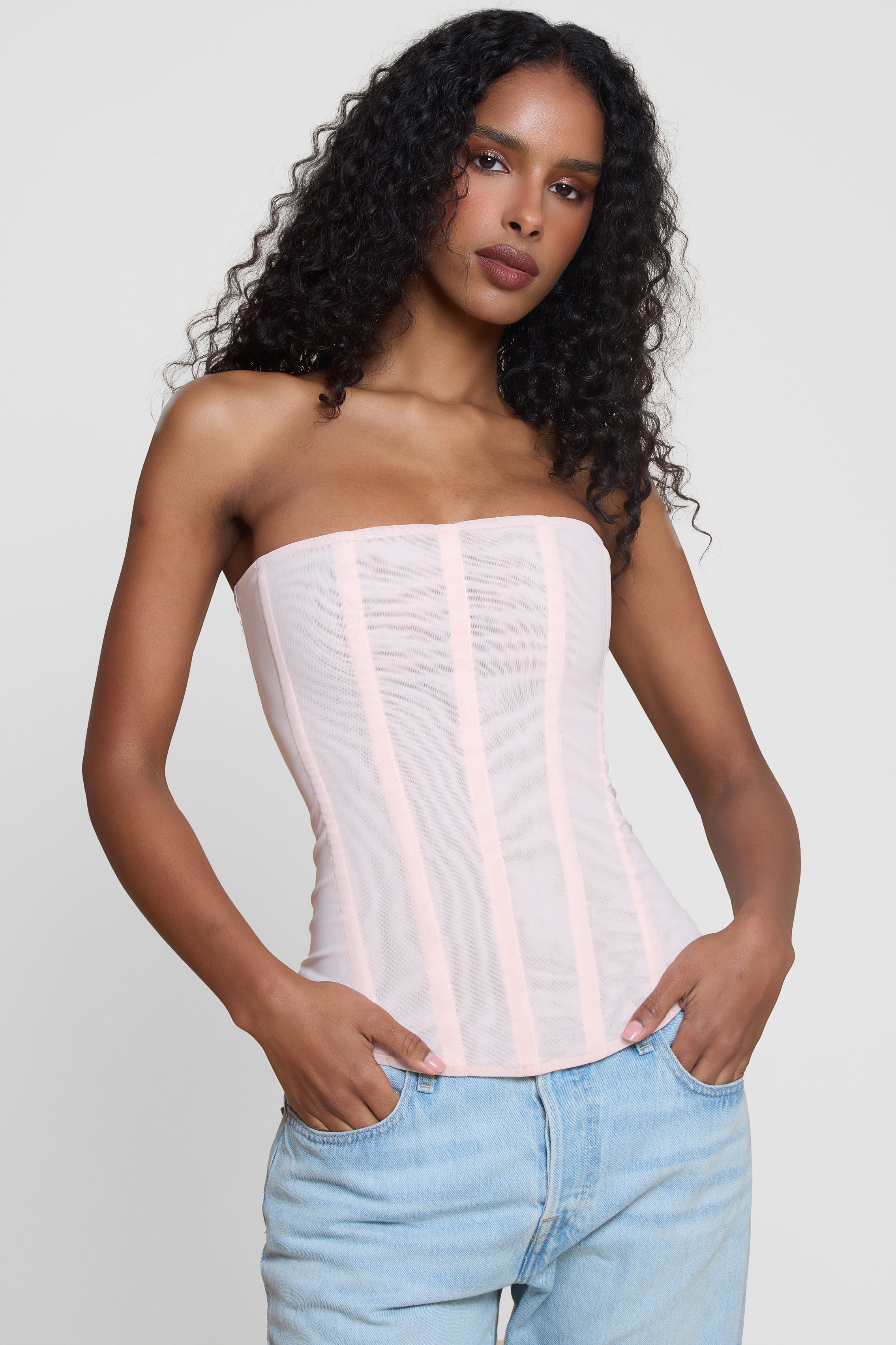 Model wearing Muse Mesh Corset Top in Pink, front view.