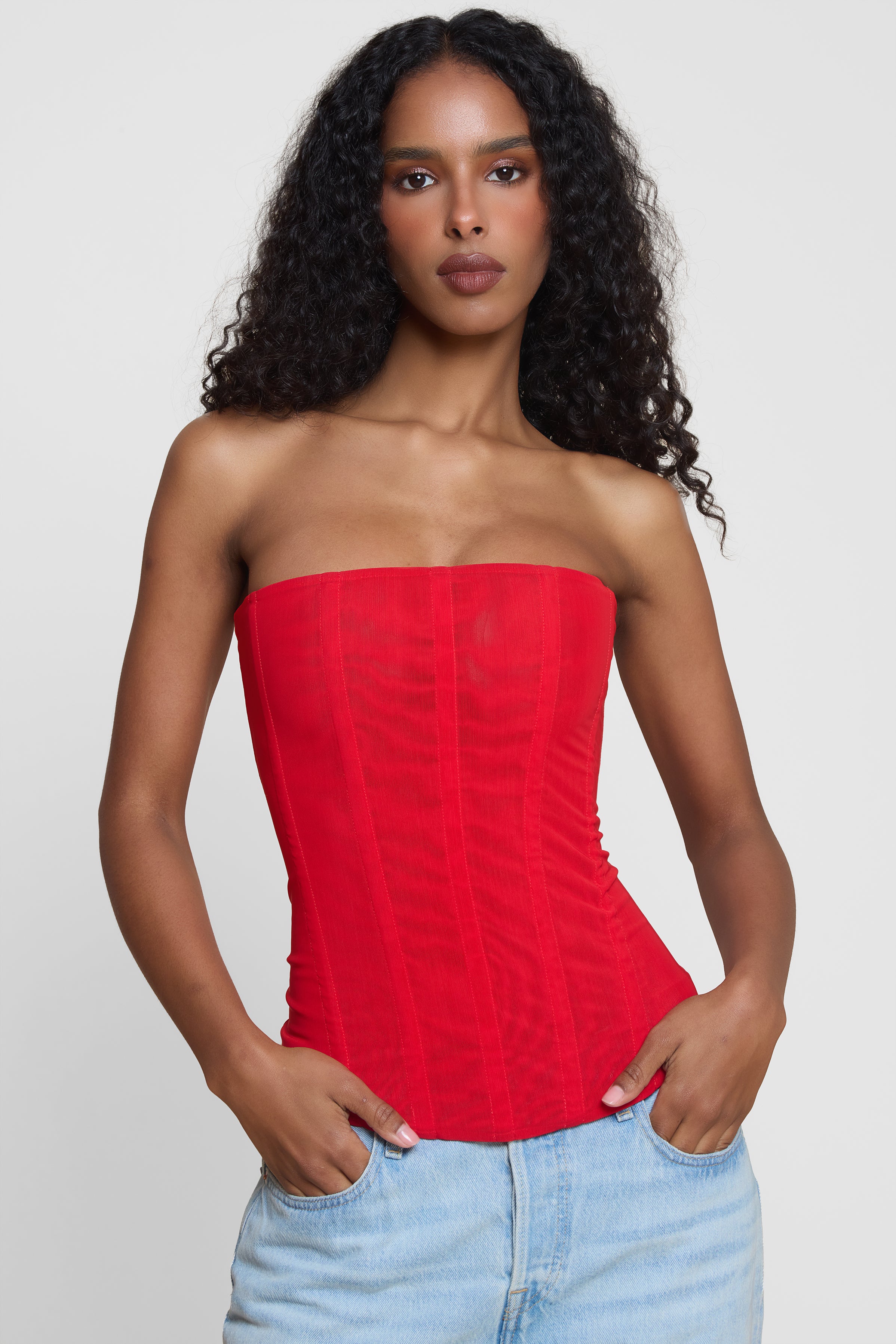 Model wearing Muse Mesh Corset Top in Red, front view.