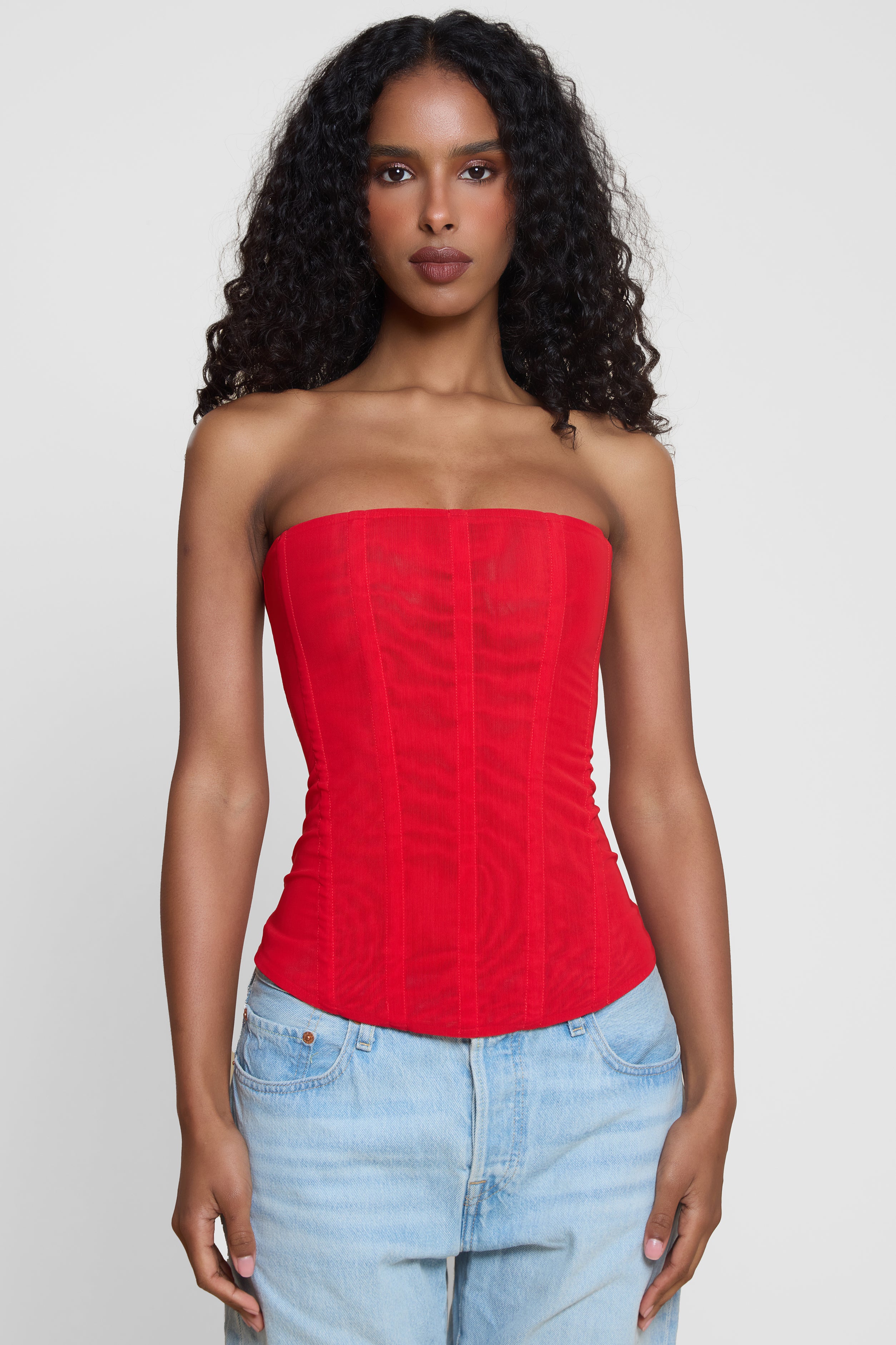 Model wearing Muse Mesh Corset Top in Red, front view.
