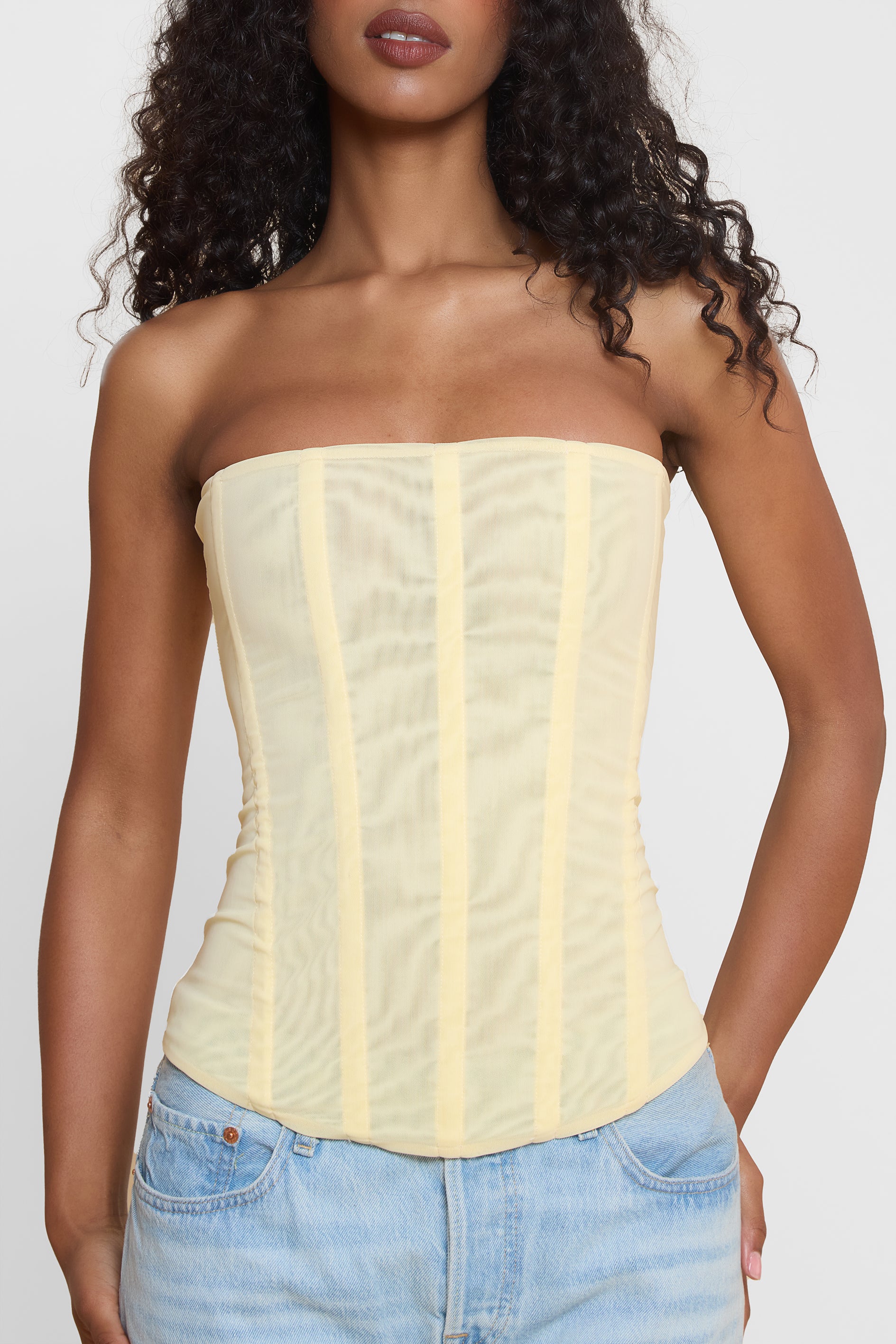 Model wearing Muse Mesh Corset Top in Yellow, front view.