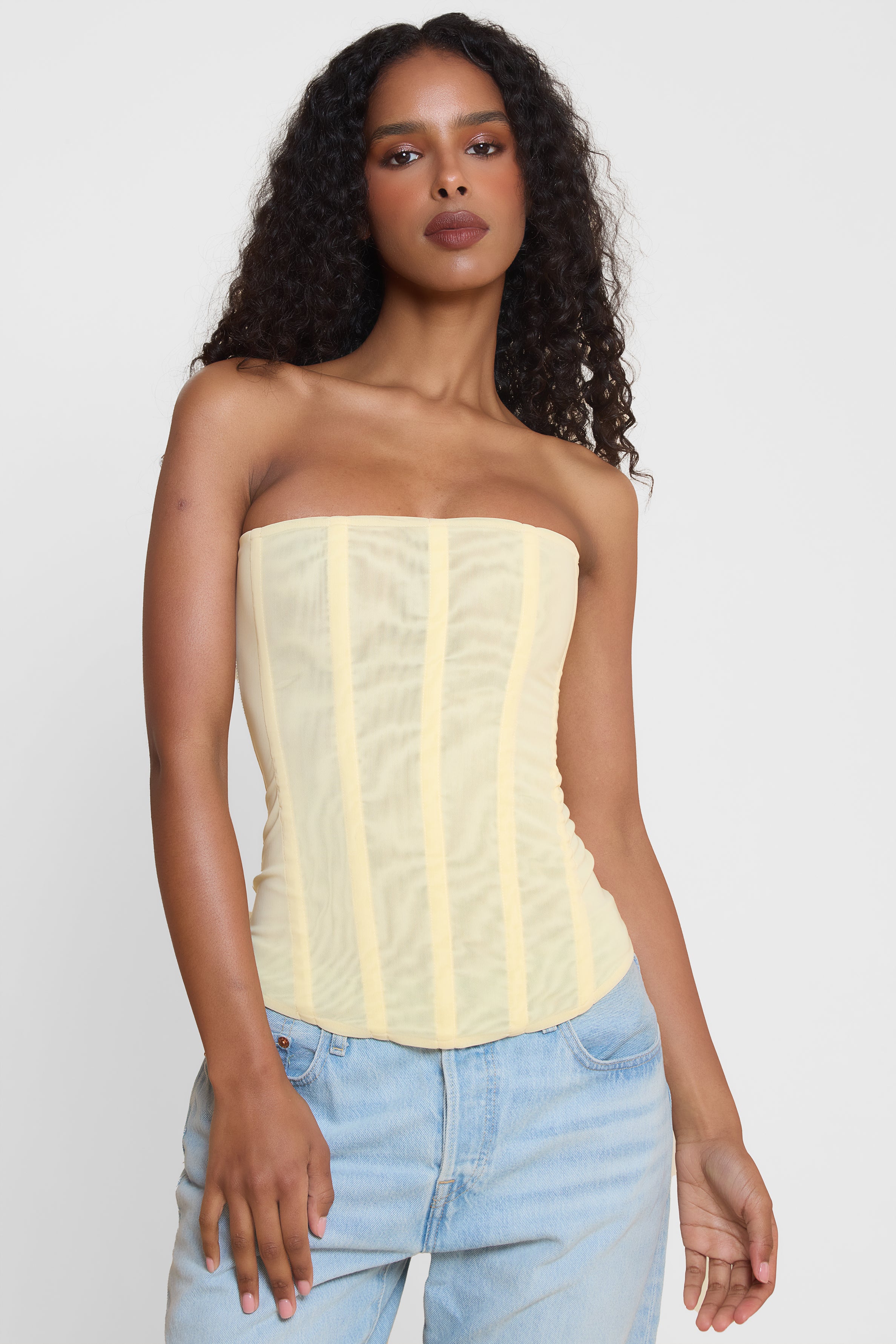 Model wearing Muse Mesh Corset Top in Yellow, front view.