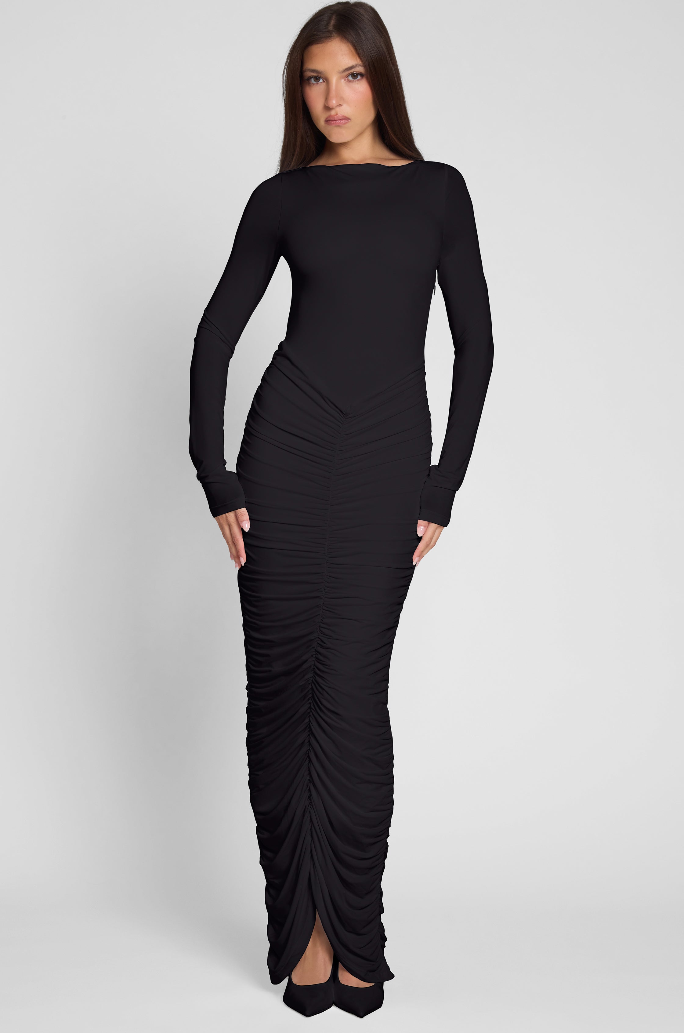 Model is wearing Rhea Ruche Maxi Dress in Black, front view.