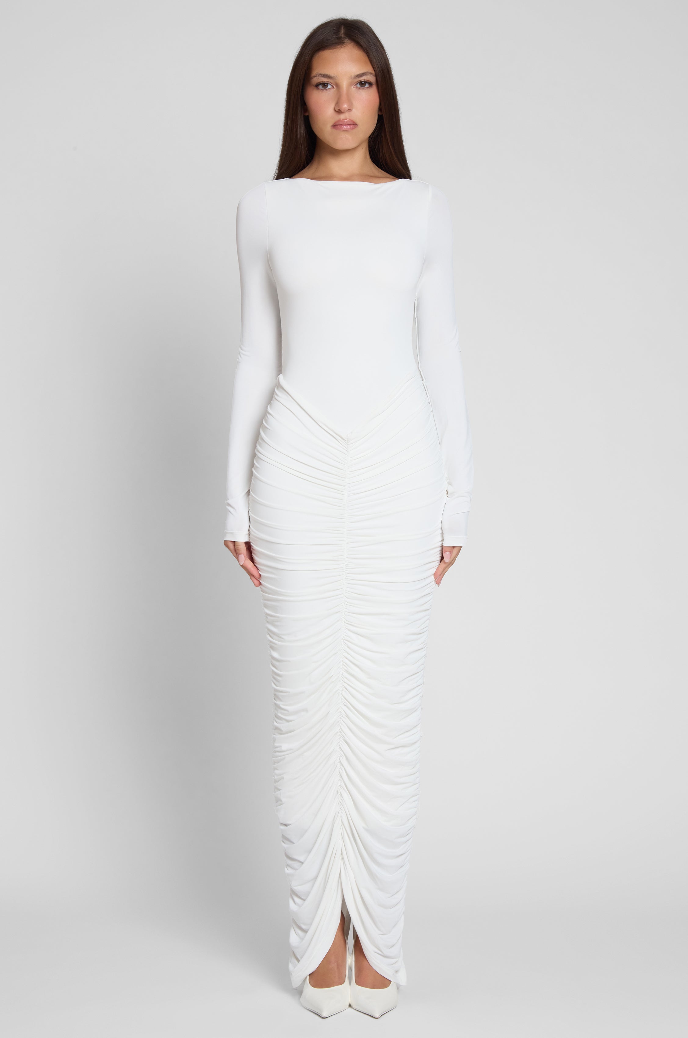 Model is wearing Rhea Ruche Maxi Dress in White, front view.
