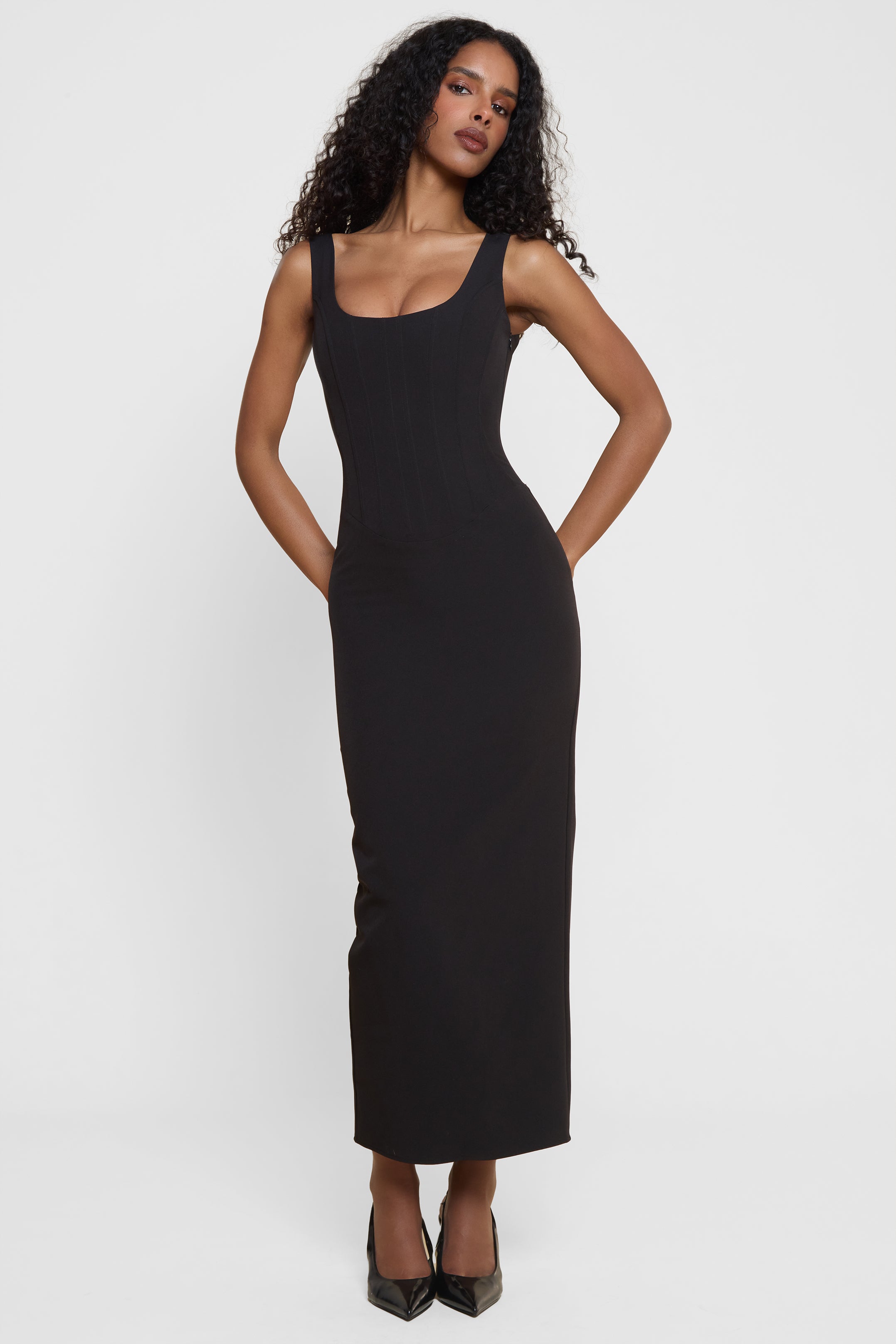 Model wearing Sancia Corset Midi Dress in Black, front view.