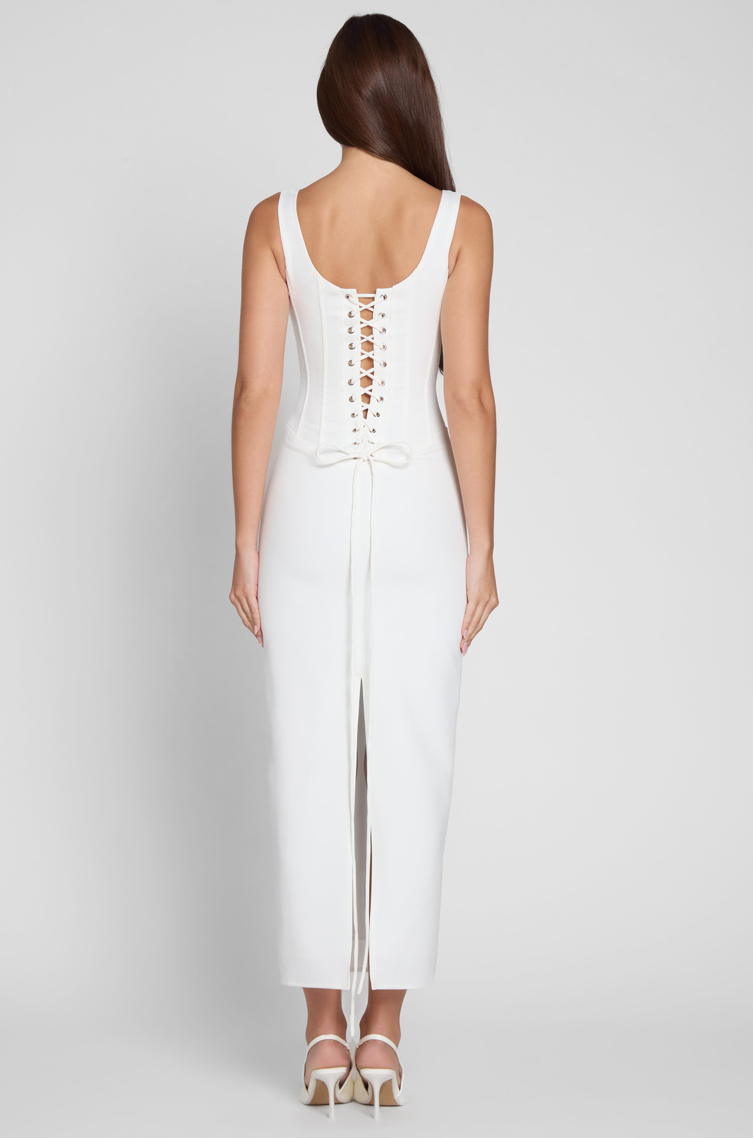 Model wearing Sancia Corset Midi Dress in White, back view.