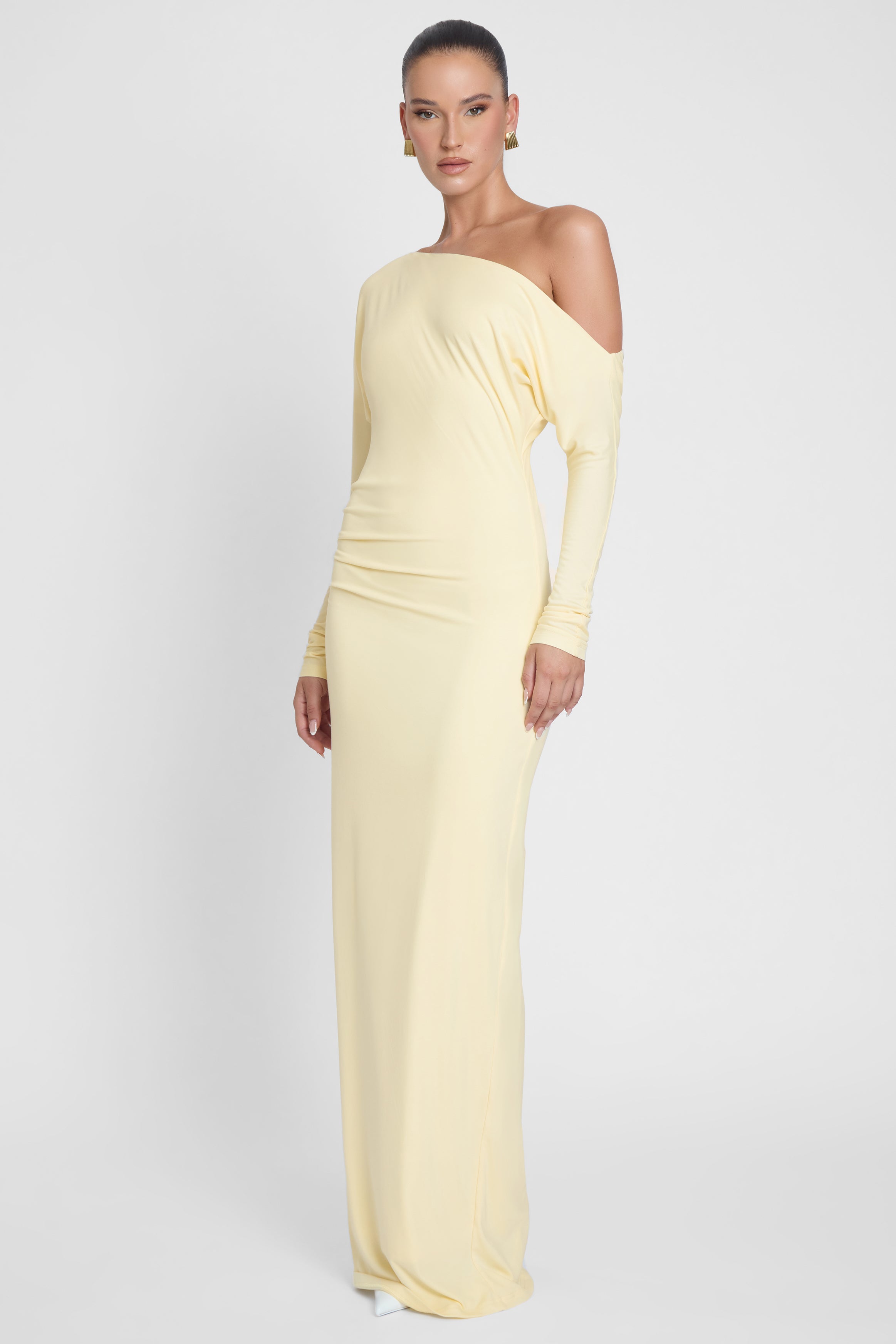 Model is wearing Sola Slouchy Jersey Maxi Dress Yellow, side view.
