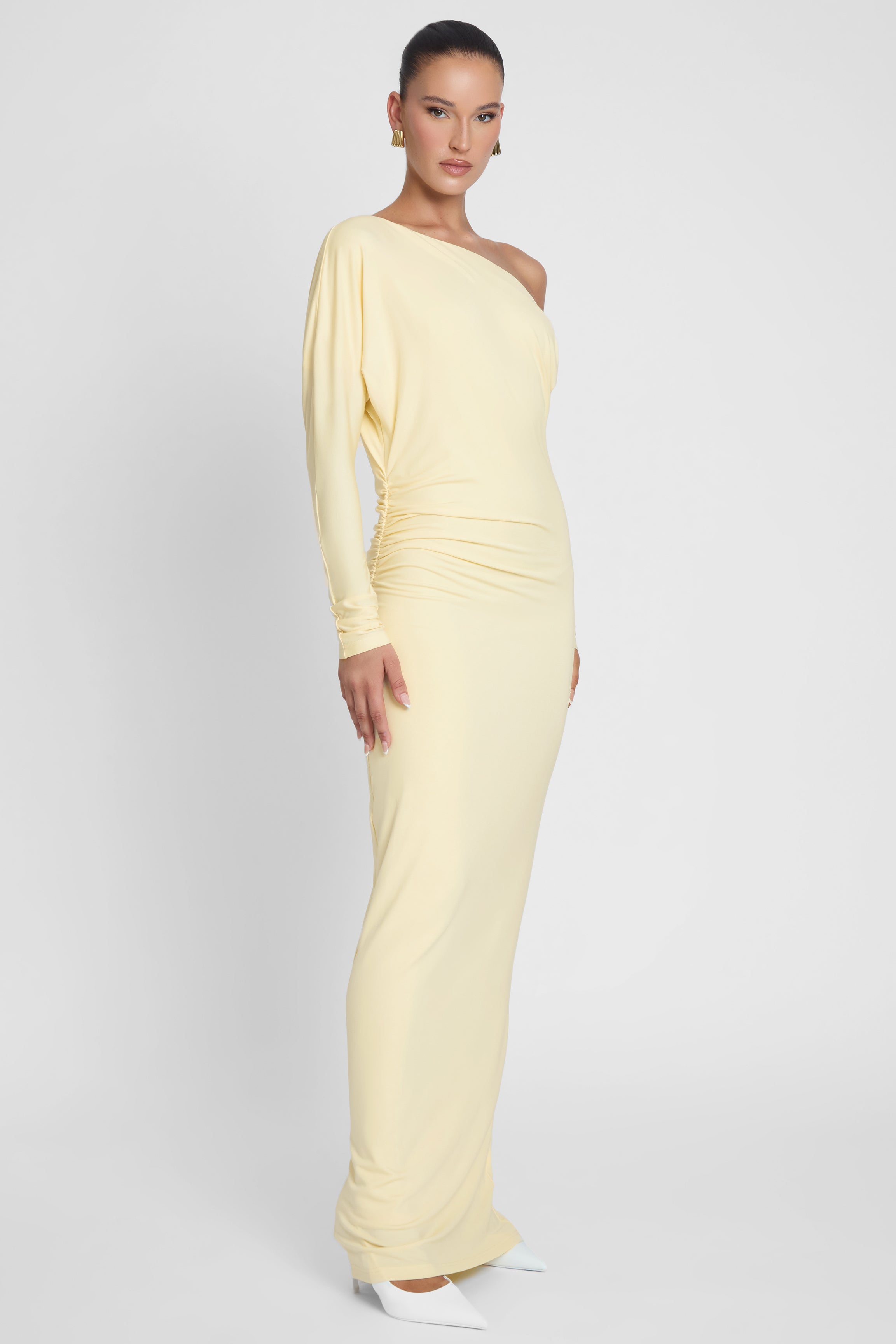 Model is wearing Sola Slouchy Jersey Maxi Dress Yellow, side view.